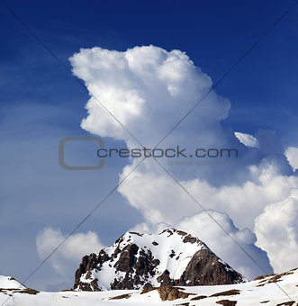 Rocks in snow and blue sky with clouds