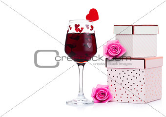 Glass of red wine with heart and pink gift box