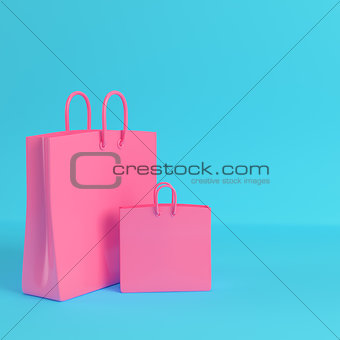 Pink shopping bags on bright blue background in pastel colors