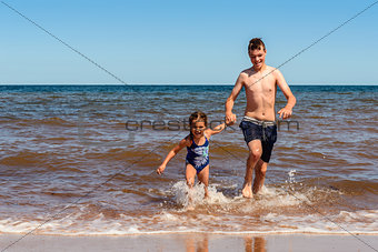 Little girl and boy playing on the Cavendish beach