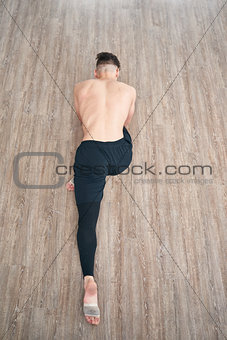 Handsome ballet dancer sitting on a splits