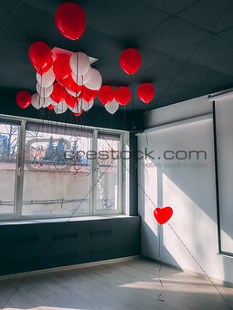 Forever along stand out red heart shape balloon in office below othe balloons. Be special Valentine concept