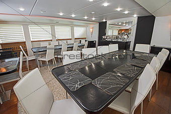 Interior of large salon dining area of luxury motor yacht