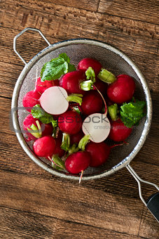Several red radishes in a sieve