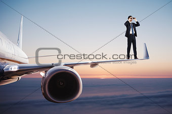 Businessman with binoculars over an aircraft searches for new business opportunities