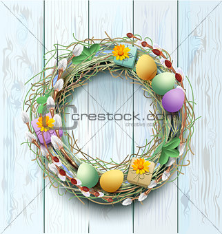 Easter wreath decoration. Branch of willow and colored eggs on blue wooden background