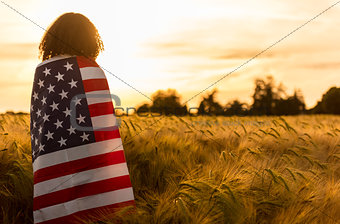 Woman Girl Teenager Wrapped in USA Flag in Field at Sunset