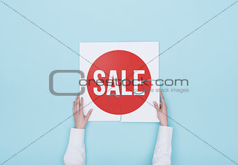 Woman completing a puzzle with a sale badge