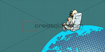 astronaut sits on the planet Earth