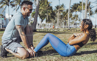 Man supporting girl with abs training