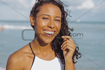 Laughing black woman in swimsuit on beach
