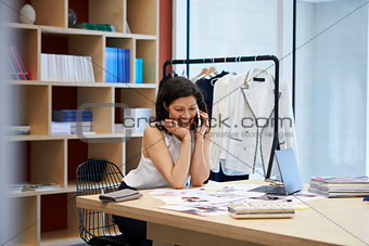 Female media creative using smartphone in office, close up
