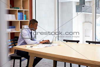 Young black businessman working alone in an office