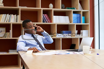 Young black businessman using smartphone in the boardroom