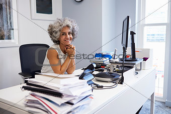Middle aged businesswoman smiling to camera in her office