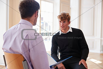 Male Teenage Student Having Discussion With Tutor