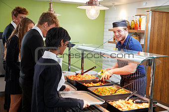 Teenage Students Being Served Meal In School Canteen