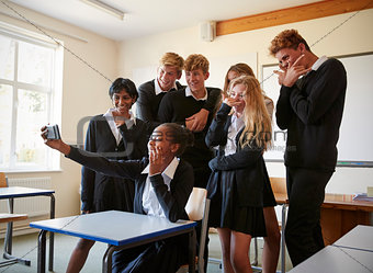 Group Of Teenage Students Posing For Selfie In Classroom