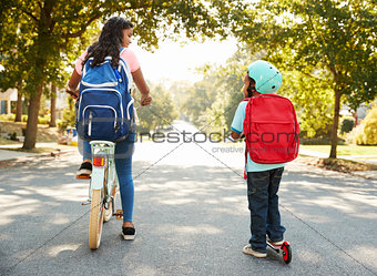 Sister With Brother Riding Scooter And Bike To School