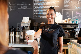 Female Barista Serving Customer With Takeaway Coffee In Cafe