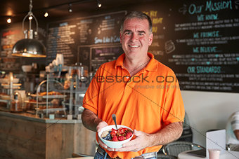 Mature Man Holding Healthy Breakfast In Coffee Shop