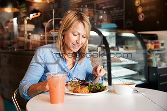 Woman In Coffee Shop Sitting At Table Eating Healthy Lunch