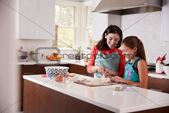 Jewish mother and daughter plaiting dough for challah bread