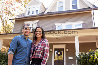 Portrait Of Smiling Couple Standing In Front Of Their Home