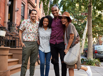 Portrait Of Friends Walking Along Urban Street In New York City
