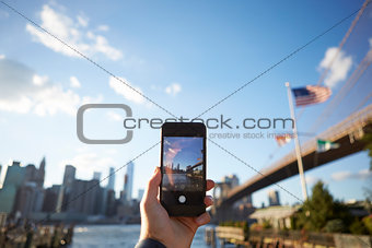 Tourist Taking Photo Of Manhattan Skyline On Mobile Phone