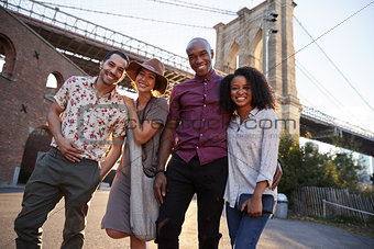 Portrait Of Friends Walking By Brooklyn Bridge In New York City