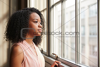 Young black businesswoman looking out of window