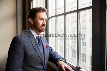 Senior white businessman looking out of window