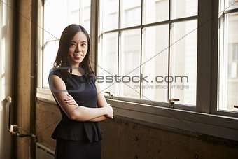 Smiling young Chinese business woman turning to camera