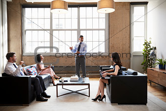 Male manager presenting at informal meeting in a lounge room