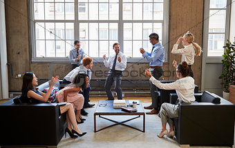 Business team celebrate hitting target at informal meeting