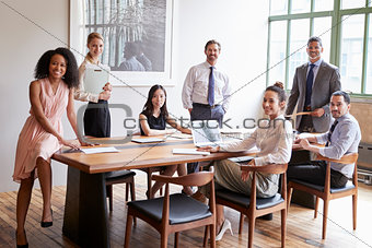Young professionals at business meeting turn to face camera