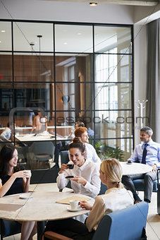Business colleagues relaxing at their office cafe, vertical