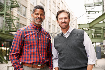 Two middle aged make colleagues outside their workplace