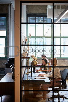 Business team working in an office booth, vertical
