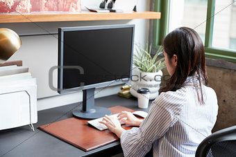 Young woman working at a computer in an office, close up