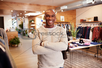 Young black man smiling to camera in a clothes shop