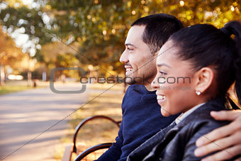 Young couple sitting on bench in Brooklyn park, close up