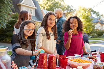 Pre-teen girls smiling to camera at a block party, close up