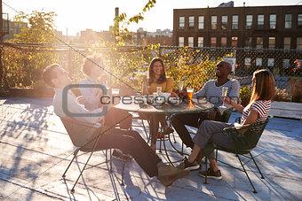 Friends talking over drinks on a New York rooftop