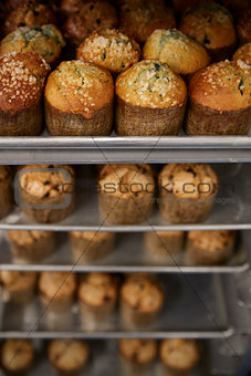 Stacked baking trays of fresh muffins at a bakery, close up