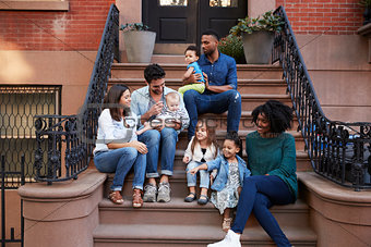 Two families with kids sitting on front stoops