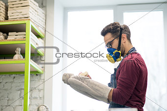 Portrait of Ceramist Dressed in an Apron Working on Clay Sculpture in Bright Ceramic Workshop.