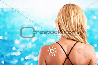 Girl in swimsuit with a sun made with sunscreen