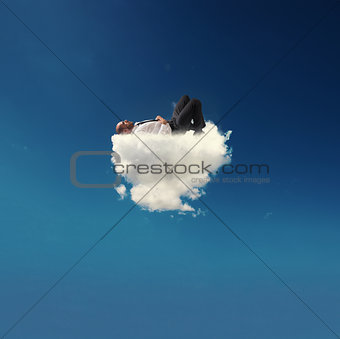 Stressed businessman relaxing on a soft cloud